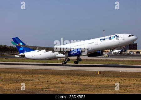 World 2 Fly Airbus A330-343 (Reg.: CS-TRH) in partenza da Malta dopo essere stato dipinto con lo schema di colori di questa compagnia aerea, è arrivato in vernice gialla il 23 giugno. Foto Stock