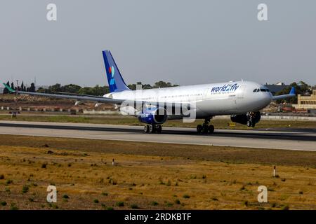 World 2 Fly Airbus A330-343 (Reg.: CS-TRH) in partenza da Malta dopo essere stato dipinto con lo schema di colori di questa compagnia aerea, è arrivato in vernice gialla il 23 giugno. Foto Stock