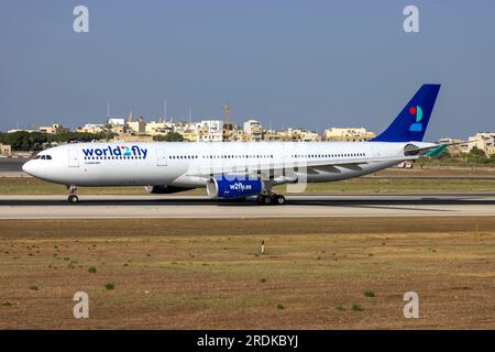 World 2 Fly Airbus A330-343 (Reg.: CS-TRH) in partenza da Malta dopo essere stato dipinto con lo schema di colori di questa compagnia aerea, è arrivato in vernice gialla il 23 giugno. Foto Stock