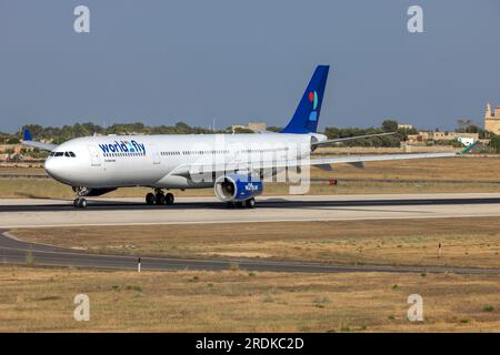 World 2 Fly Airbus A330-343 (Reg.: CS-TRH) in partenza da Malta dopo essere stato dipinto con lo schema di colori di questa compagnia aerea, è arrivato in vernice gialla il 23 giugno. Foto Stock