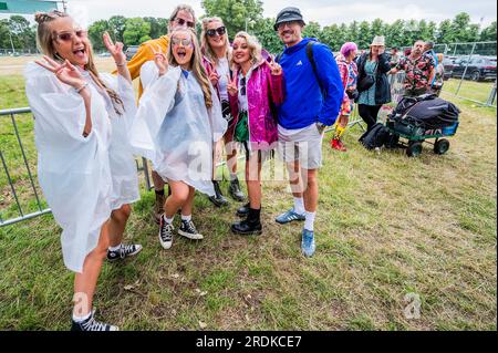 Henham Park, Suffolk, Regno Unito. 22 luglio 2023. I visitatori del giorno arrivano preparati per il tempo umido previsto mentre aspettano che il sito apra in coda con i campeggiatori del fine settimana - il Festival Latitude 2023, Henham Park. Crediti: Guy Bell/Alamy Live News Foto Stock