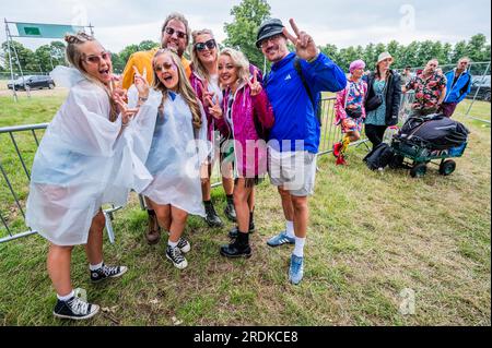 Henham Park, Suffolk, Regno Unito. 22 luglio 2023. I visitatori del giorno arrivano preparati per il tempo umido previsto mentre aspettano che il sito apra in coda con i campeggiatori del fine settimana - il Festival Latitude 2023, Henham Park. Crediti: Guy Bell/Alamy Live News Foto Stock