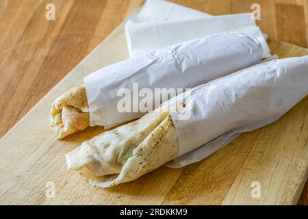 Panini shawarma freschi pronti da mangiare su un tagliere di legno Foto Stock