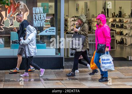 Preston Lancashire. Meteo Regno Unito 22 luglio 2023. Saldi estivi, negozi e acquirenti in un giorno di pioggia nel centro della città. Secondo le previsioni, "la pioggia, a volte pesante, fino al sabato e alla domenica, è probabile che causi qualche disturbo, in particolare per gli eventi all'aperto. Crediti: MediaWorldImages/AlamyLiveNews Foto Stock