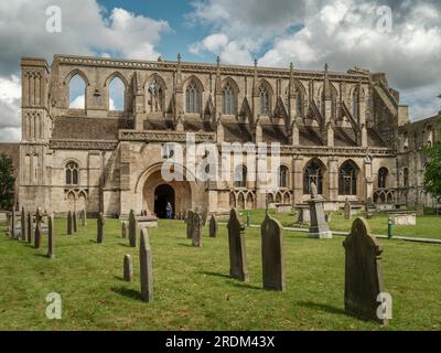 Il sole d'estate illumina la facciata della storica abbazia nella città di mercato di Cotswold a Malmesbury. La storica abbazia fu fondata come benedettina Foto Stock