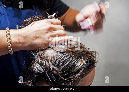 la parrucchiera femminile taglia i peli in eccesso prima di tagliarli. Master class sul taglio di capelli da uomo Foto Stock