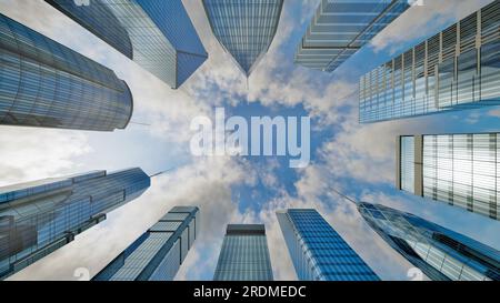 Nuvole su cielo blu che passano sopra grattacieli edifici commerciali al mattino Foto Stock