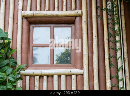 Le finestre delle case di legno all'esterno sono coperte da splendidi alberi. Foto Stock