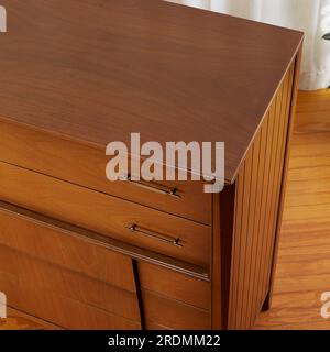 Dresser alto moderno di metà secolo in noce. Eleganti mobili vintage per la camera da letto. Foto Stock