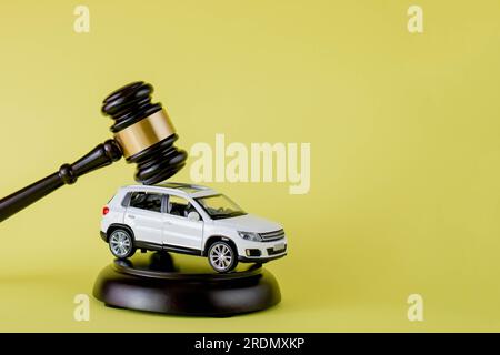 Concetto d'asta per auto - martelletto e chiave auto su sfondo giallo. Causa per incidente o assicurazione, caso giudiziario Foto Stock