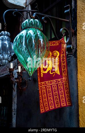 Bandiera della Repubblica di Venezia con il Leone di San Marco e una lampada a sospensione in gabbia veneziana a Venezia. Foto Stock