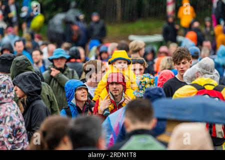 Henham Park, Suffolk, Regno Unito. 22 luglio 2023. Il tempo cambia a causa della pioggia prolungata e le persone rispondono in modo diverso: Alcuni indossano poncho usa e getta, altri continuano a bagnarsi, la maggior parte è ancora di buon umore - il Festival Latitude 2023, Henham Park. Crediti: Guy Bell/Alamy Live News Foto Stock