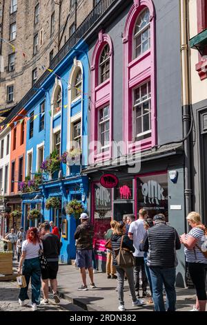 Una folla di persone a Victoria Street, con le colorate facciate dei negozi dipinte, Edimburgo, Scozia, Regno Unito Foto Stock