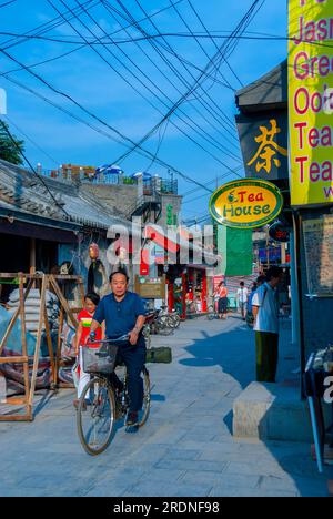 Pechino, CINA - piccoli gruppi, Old Neighborhood Street Scene - Hutong, Crowd People Walking, Man Cycling, a Guanfang Hutong, Financial Street area, cartelli per la casa del tè, strade trafficate pechino Foto Stock