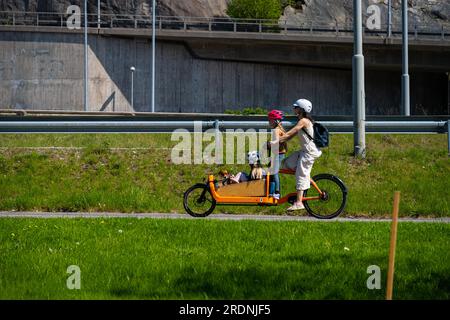 Famiglia che viaggia su una bicicletta elettrica assistita Yellow Cargo Foto Stock