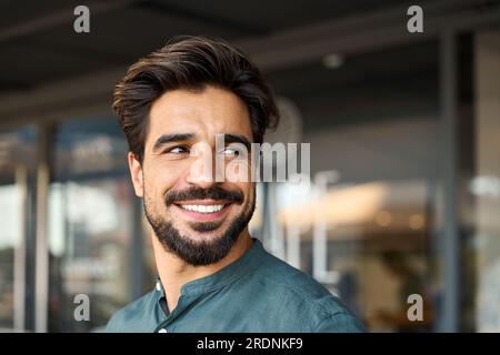 Giovane uomo d'affari sorridente che guarda lontano, ritratto da vicino. Copia spazio Foto Stock