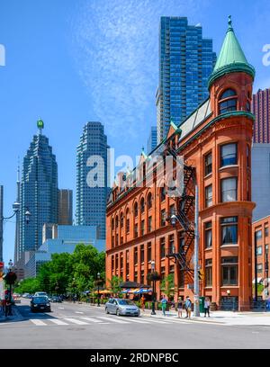 Toronto, Canada - 19 luglio 2023: Esterno dell'edificio Gooderham. I moderni grattacieli del dsitrict finanziario sono in lontananza Foto Stock