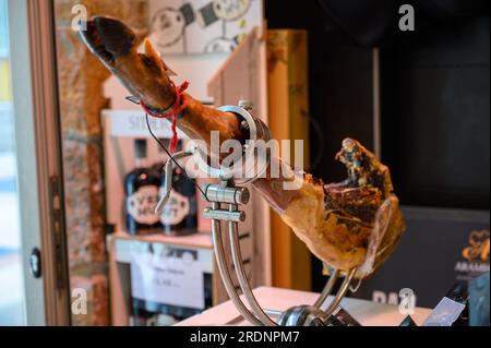 Coscia di suino serrano Iberian Saled Jamon in stand in macelleria spagnola da vicino Foto Stock