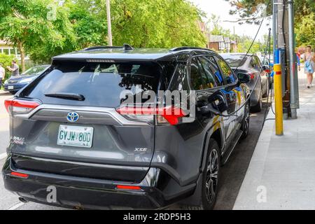 Toronto, Canada - 9 luglio 2023: L'auto elettrica Toyota viene caricata da un caricabatterie in una strada cittadina. Foto Stock