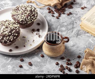 Chicchi di caffè arrosto in tazza e torta con texture grigia sfondo Foto Stock