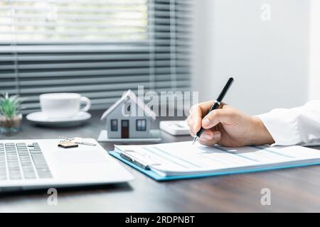 Modello di casa con agente immobiliare e cliente discutere per contratto di acquistare casa, assicurazione o prestito immobiliare background. Foto Stock