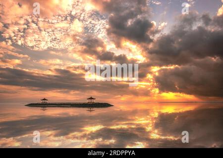 Tramonto o alba sulla spiaggia di Bali a Sanur. bellissimi templi in acque calme dai colori fantastici Foto Stock