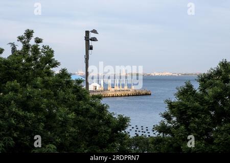 Vista della Statua della libertà da Brooklyn Bridge Park, un parco sul lato di Brooklyn dell'East River a New York City. Foto Stock