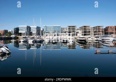 Barche a vela ed edifici che si riflettono nelle lisce acque del porto interno di Tallinn. Edifici in costruzione Foto Stock