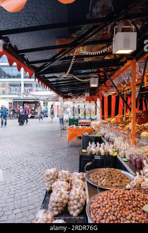 Bonn, Germania - 19 maggio 2023: Veduta di un mercato all'aperto che vende dolciumi, frutta fresca e verdura nella piazza del mercato di Bonn, Germania Foto Stock