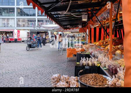 Bonn, Germania - 19 maggio 2023: Veduta di un mercato all'aperto che vende dolciumi, frutta fresca e verdura nella piazza del mercato di Bonn, Germania Foto Stock