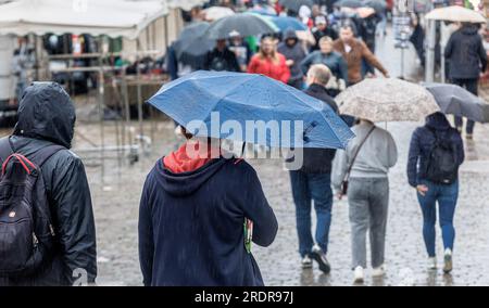 Amburgo, Germania. 23 luglio 2023. A causa della pioggia continua, gli ombrelli determinano l'immagine sul mercato del pesce. Credito: Markus Scholz/dpa/Alamy Live News Foto Stock