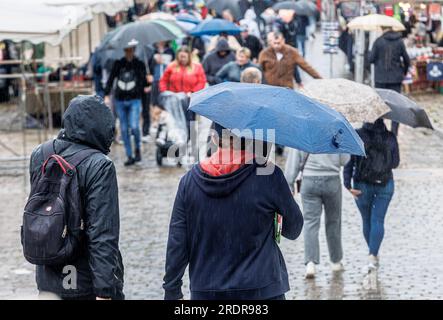 Amburgo, Germania. 23 luglio 2023. A causa della pioggia continua, gli ombrelli determinano l'immagine sul mercato del pesce. Credito: Markus Scholz/dpa/Alamy Live News Foto Stock