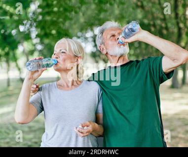 outdoor senior fitness donna uomo stile di vita sport attivo esercizio sano corridore coppia corsa jogging anziani maturo bottiglia d'acqua bere sete Foto Stock
