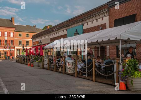 Newburyport, Massachusetts, US-13 luglio 2023: Scena di strada nel centro cittadino con edifici in mattoni del XIX secolo, negozi alla moda e ristoranti all'aperto. Foto Stock