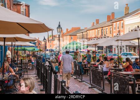 Newburyport, Massachusetts, US-13 luglio 2023: Scena di strada nel centro cittadino con edifici in mattoni del XIX secolo, negozi alla moda e ristoranti all'aperto. Foto Stock