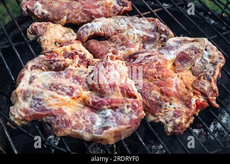 Bistecca di maiale marinata cruda tagliata su griglia. Foto Stock