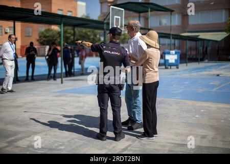 Madrid, Spagna. 23 luglio 2023. Un agente della polizia nazionale spagnola aiuta una coppia a identificare il proprio seggio elettorale durante le elezioni politiche spagnole, al Ramiro de Maetzu College, a Madrid. Credito: SOPA Images Limited/Alamy Live News Foto Stock