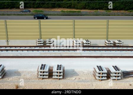 Posa di nuovi binari ferroviari. Materiali da costruzione in acciaio e traverse. Linea ferroviaria ad alta velocità ICE. Auto sull'autostrada. Wendlingen, Ulm, A8. Foto Stock