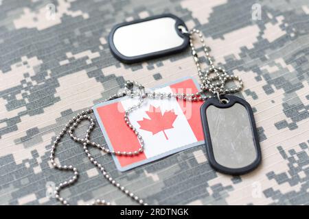 bianco esercito, tag cane con bandiera del canada sullo sfondo della trama kaki. concetto militare Foto Stock