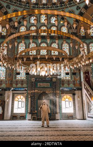 I lavoratori spruzzano disinfettante nelle moschee come parte delle misure preventive contro la diffusione del coronavirus COVID-19. Foto Stock