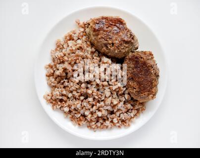 Porridge di grano saraceno con polpettine di carne. Deliziosa colazione a base di carne su un piatto. Foto Stock