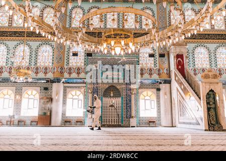 I lavoratori spruzzano disinfettante nelle moschee come parte delle misure preventive contro la diffusione del coronavirus COVID-19. Foto Stock