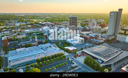 Alba d'estate con luce arancione sopra lo skyline del centro di Fort Wayne, architettura degli affari e dello skyline cittadino Foto Stock