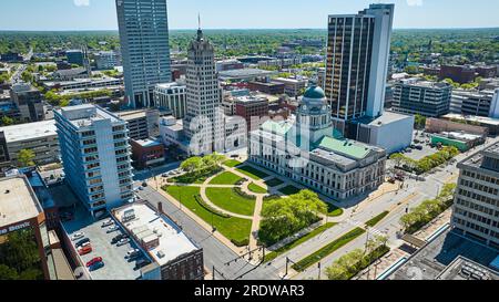 Prato verde e alberi presso i grattacieli del paesaggio urbano del tribunale di Fort Wayne vicino al tribunale aereo del centro città Foto Stock