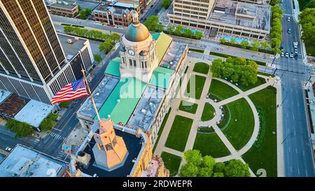 Bandiera degli Stati Uniti rossa, bianca e blu sopra l'alba aerea estiva del tribunale di Fort Wayne Foto Stock