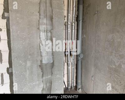 Nuovi tubi in plastica e polipropilene in plastica e in polipropilene per acqua e fognature in isolamento termico con contatori d'acqua in una nuova casa senza riparazioni. Foto Stock