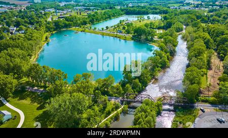 Aereo del Parco della Fondazione Ariel con ponte ferroviario e splendido laghetto di color verde ottanio e alberi estivi Foto Stock