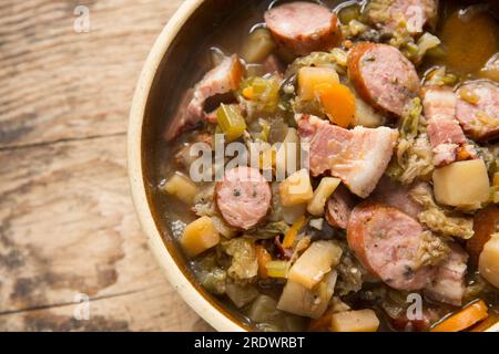 Un eintopf fatto in casa in una pentola a cottura lenta con verdure in gran parte radicali e cavolo con salsiccia di maiale polacca alle erbe e pancetta affumicata. Inghilterra U Foto Stock