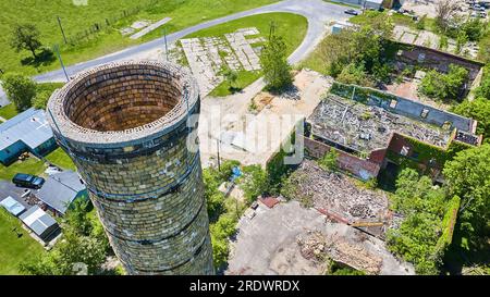 Alto silo Smokestack aereo vicino a vecchie macerie abbandonate, pareti verdi di edera IN CUI si trova il Pierceton Foto Stock