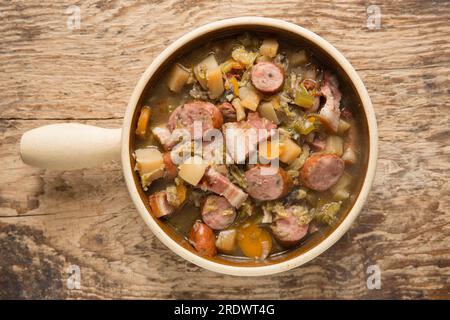 Un eintopf fatto in casa in una pentola a cottura lenta con verdure in gran parte radicali e cavolo con salsiccia di maiale polacca alle erbe e pancetta affumicata. Inghilterra U Foto Stock